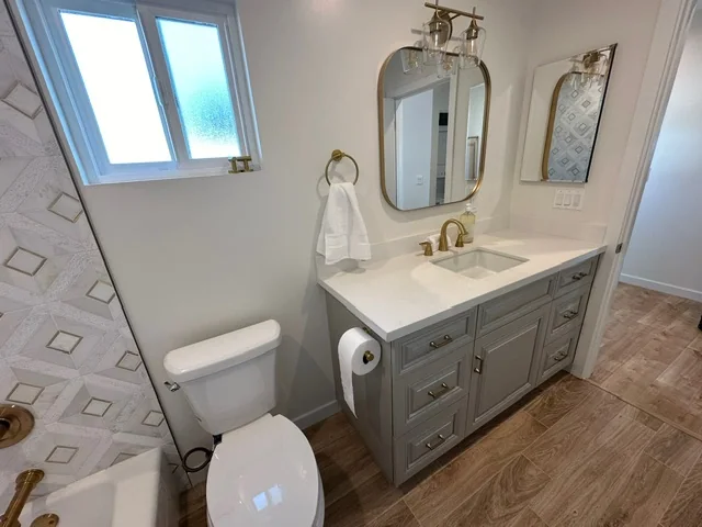 Modern bathroom with gold accents, patterned tile and custom vanity