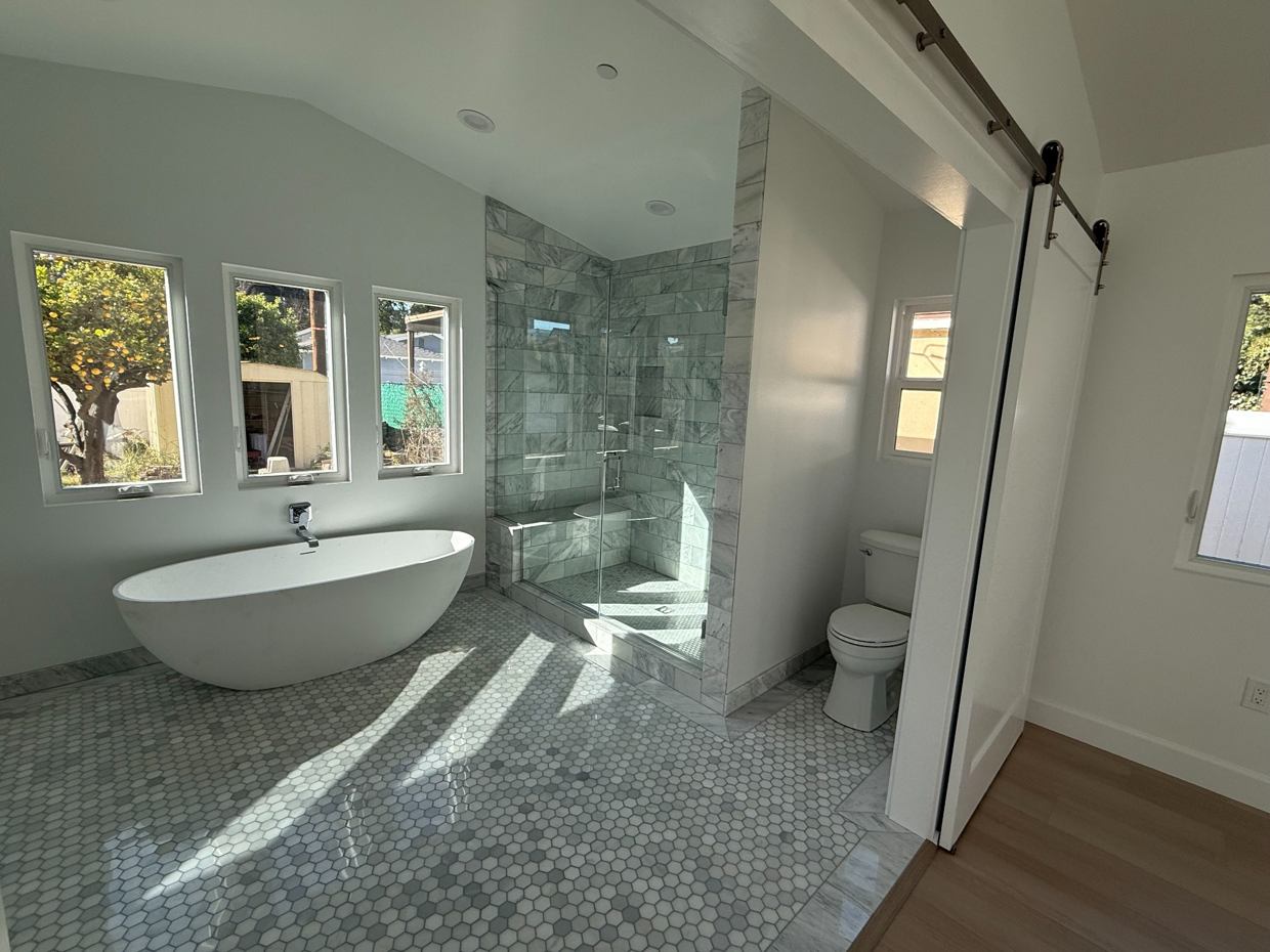 Contemporary Bathroom Renovation: Freestanding tub, double vanity and clean marble-inspired finishes.